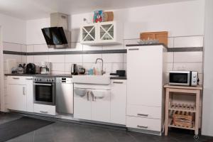 a kitchen with white appliances and a microwave at Yn e Homeie in Baar