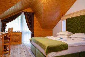 1 dormitorio con 1 cama grande y techo de madera en Casa Baciu, en Fundu Moldovei
