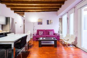 a living room with a purple couch and chairs at Apartamento con patio junto a la Catedral by Toledo AP in Toledo