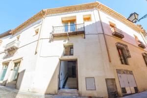 - un bâtiment blanc avec 2 balcons et une porte dans l'établissement Apartamento con patio junto a la Catedral by Toledo AP, à Tolède