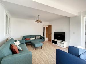 a living room with two blue couches and a tv at La VILLA Ismaila in Sainte-Feyre