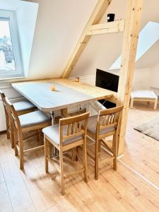 comedor con mesa de madera y sillas en Stadthaus Apartment Bachperle, en Mayen
