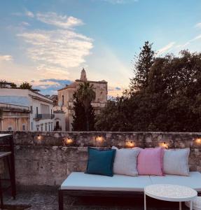 un sofá blanco sentado en una pared con una mesa en Dimora San Giuseppe, en Lecce