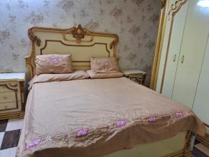 ein Schlafzimmer mit einem großen Bett mit rosa Bettwäsche und Kissen in der Unterkunft Hijaz Street Hotel in Kairo