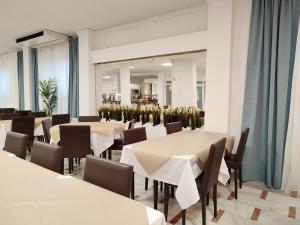 ein Esszimmer mit Tischen, Stühlen und einem Spiegel in der Unterkunft Hotel Porto in Gandía