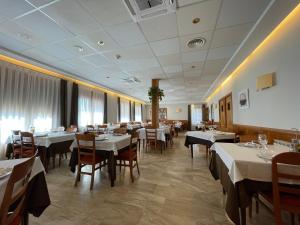 a dining room with white tables and chairs at Hotel Arturo in La Pobleta de Bellvei