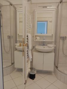 a white bathroom with a sink and a mirror at Ostseekrabbe in Timmendorfer Strand