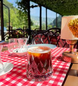 una mesa con una bebida en un vaso sobre un mantel a cuadros en DREAM RIVER EXCLUSIVE BUNGALOW en Çamlıhemşin