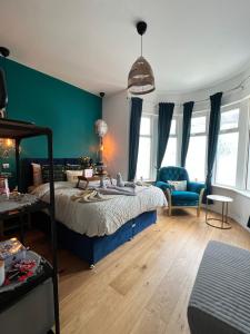 um quarto com uma cama e uma parede azul em Flamingo Lodge em Torquay