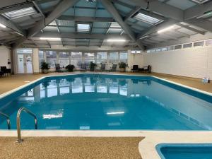 a large pool with blue water in a building at Whitsand Bay Tamar Bedroom in Downderry