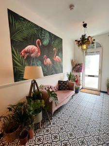 a living room with a pink couch and a painting of flamingos at Flamingo Lodge in Torquay