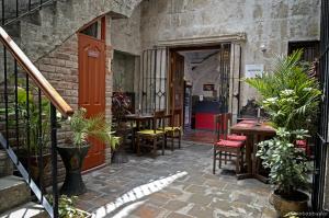 a patio with a table and chairs and plants at Hostal Bubamara in Arequipa