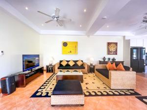 un salon avec des canapés et une télévision à écran plat dans l'établissement 3-4BR Laguna Phuket Golf Course Villa with Pool & Jacuzzi, à Laguna Phuket