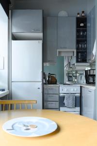 uma cozinha com uma mesa e um frigorífico branco em Hip studio near Central Park and City Center em Helsinque
