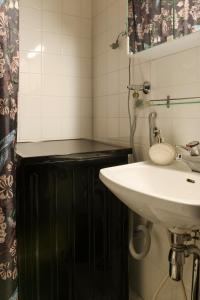 uma casa de banho com um lavatório e um espelho em Hip studio near Central Park and City Center em Helsinque