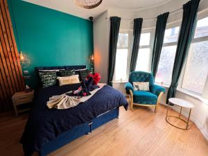 a bedroom with a bed and a blue wall at Flamingo Lodge in Torquay
