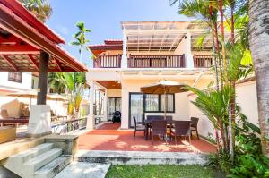 une image d'une maison avec une terrasse dotée d'une table et de chaises dans l'établissement 3-4BR Laguna Phuket Golf Course Villa with Pool & Jacuzzi, à Laguna Phuket