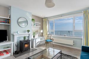 Dolphins Apartment - Spectacular Sea Views في ساندرزفوت: غرفة معيشة مع موقد وإطلالة على المحيط