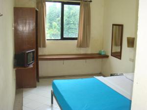 a bedroom with a blue bed and a window at Sunset View Carita by Augusta hotel in Sukanegara