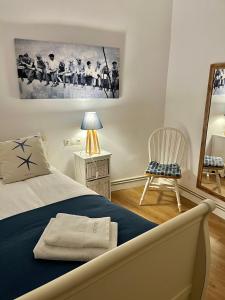1 dormitorio con cama, silla y espejo en El Botxito, en Bilbao