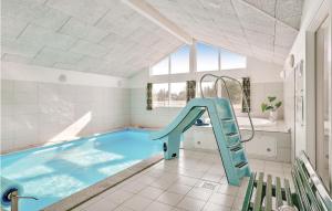 a swimming pool with a blue slide in a room at Beautiful Home In lbk With Kitchen in Ålbæk