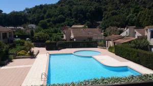 a large swimming pool in a yard with houses at Résidence Cap Azur Appartement 237 in Villeneuve-Loubet