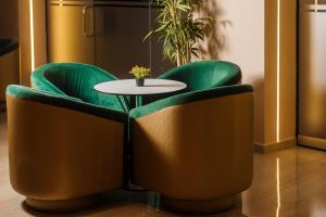 a table and two green chairs with a white table at Gloria Palace Hotel & SPA in Golem