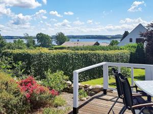 a wooden deck with a table and chairs on it at Two-Bedroom Holiday home in Stege 5 in Grevinge