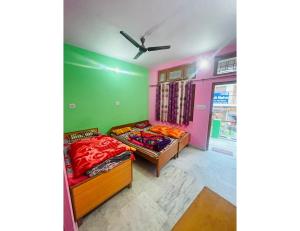 two beds in a room with green and pink walls at Hotel Maharishi, Uttarkashi in Uttarkāshi