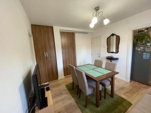 a dining room with a table and chairs and a television at Apartment La Romana in Podgorica