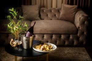 uma mesa com um prato de comida e uma garrafa de vinho em Gloria Palace Hotel & SPA em Golem