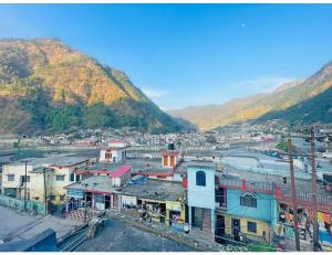 un gruppo di edifici con montagne sullo sfondo di Hotel Maharishi, Uttarkashi a Uttarkāshi