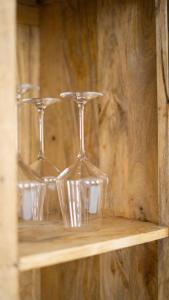 three wine glasses sitting on a wooden shelf at Casa Mare in Meiningen