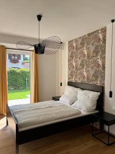 Ferienwohnungen Rössle في Stiefenhofen: غرفة نوم مع سرير مع لوحة كبيرة على الحائط