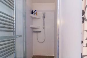 łazienka z prysznicem i szklanymi drzwiami w obiekcie Le Suffren-Eiffel Appartement w Paryżu