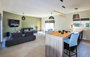 een keuken en een woonkamer met een tafel en een bank bij 4 Bedroom Stunning Home In Clon Dandran in Cléon-dʼAndran