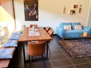 a living room with a table and a blue couch at Gebirgszauber in Walchsee