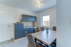 a kitchen and dining room with a wooden table and chairs at Damar Apartmani in Senj