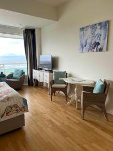 a bedroom with a bed and a table and chairs at Annet's Studio in Zandvoort