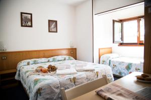 a bedroom with two beds and a table with two tables at Hotel Marguareis in Limone Piemonte