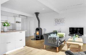 uma cozinha e sala de estar com um fogão num quarto em 4 Bedroom Awesome Home In Dronningmlle em Dronningmølle