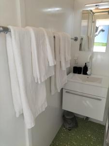 uma casa de banho com toalhas brancas penduradas num cabide em Havenkantoortje em Woudsend