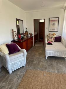uma sala de estar com duas cadeiras e um sofá em Harbour View House em Port Elizabeth