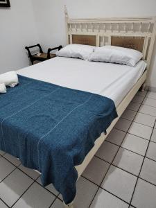 a large bed with a blue blanket on it at Casa Porto de Pedras_Patacho_Milagres in Pôrto de Pedras