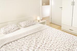 biała sypialnia z łóżkiem z 2 poduszkami w obiekcie Ferienhaus mit Meerblick & Pool in Baška - Villa-Planina w Bašce