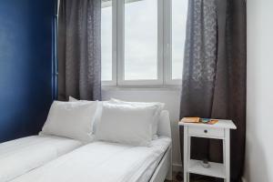 - un lit avec des oreillers blancs à côté d'une fenêtre dans l'établissement ShortStayPoland Grochowska (B112), à Varsovie