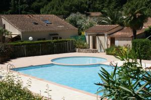 una piscina in un cortile con una casa di Résidence Cap Azur Appartement 215 a Villeneuve-Loubet