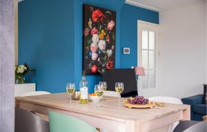 uma sala de jantar com uma mesa de madeira e copos de vinho em Beautiful Home In Breukelen With Wifi em Breukelen