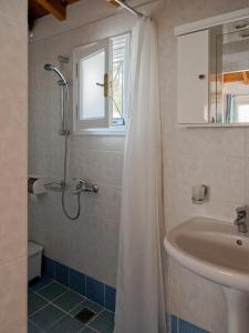a bathroom with a shower curtain and a sink at Summer Garden Studio - village location in Koroni