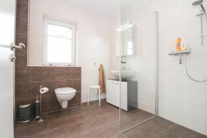 a bathroom with a toilet and a sink at Dünentau in Norden +15 photos